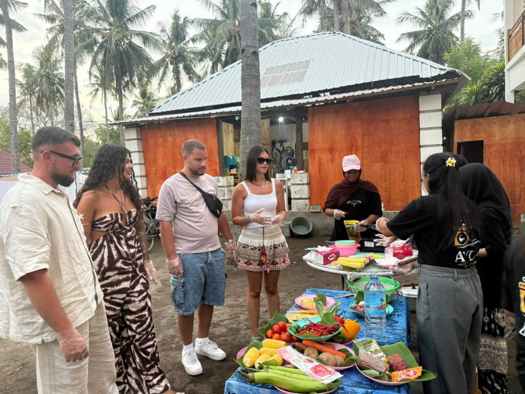 The host family's home on Gili Trawangan, palm trees behind and a table of fresh vegetables in front