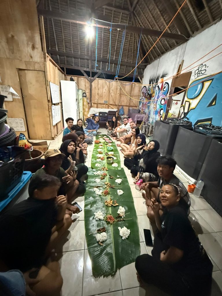 The long banana-leaf table set for dinner with guests and family seated either side